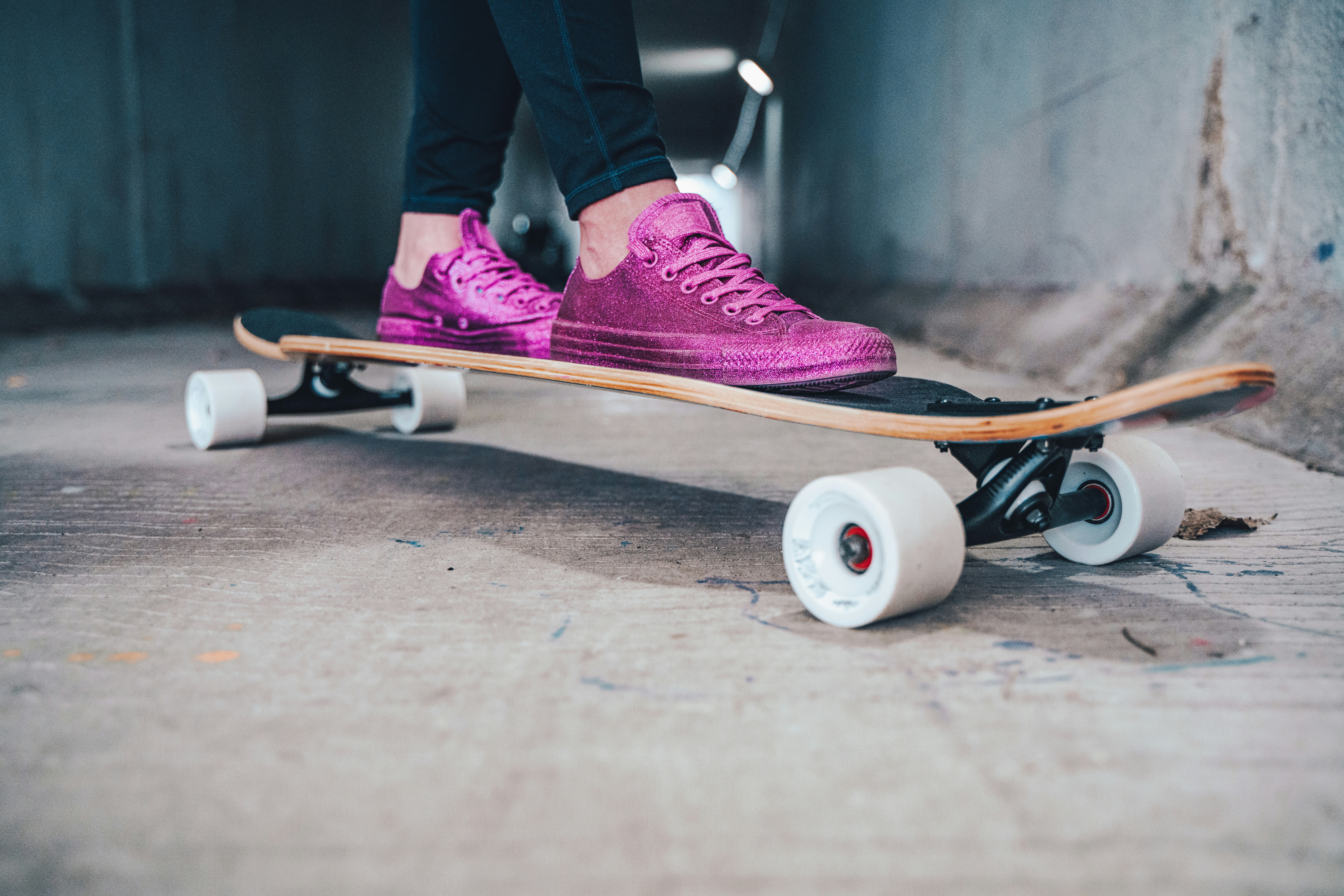 person in purple nike sneakers riding white and black skateboard